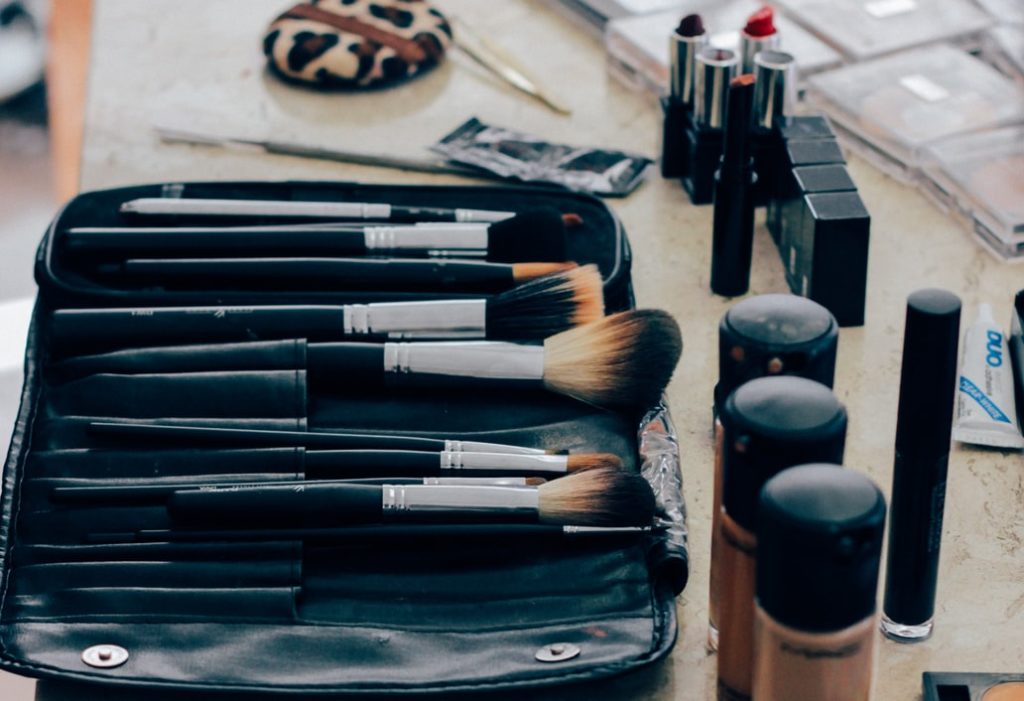 Makeup products are laid out that includes makeup brushes, not beauty blenders.